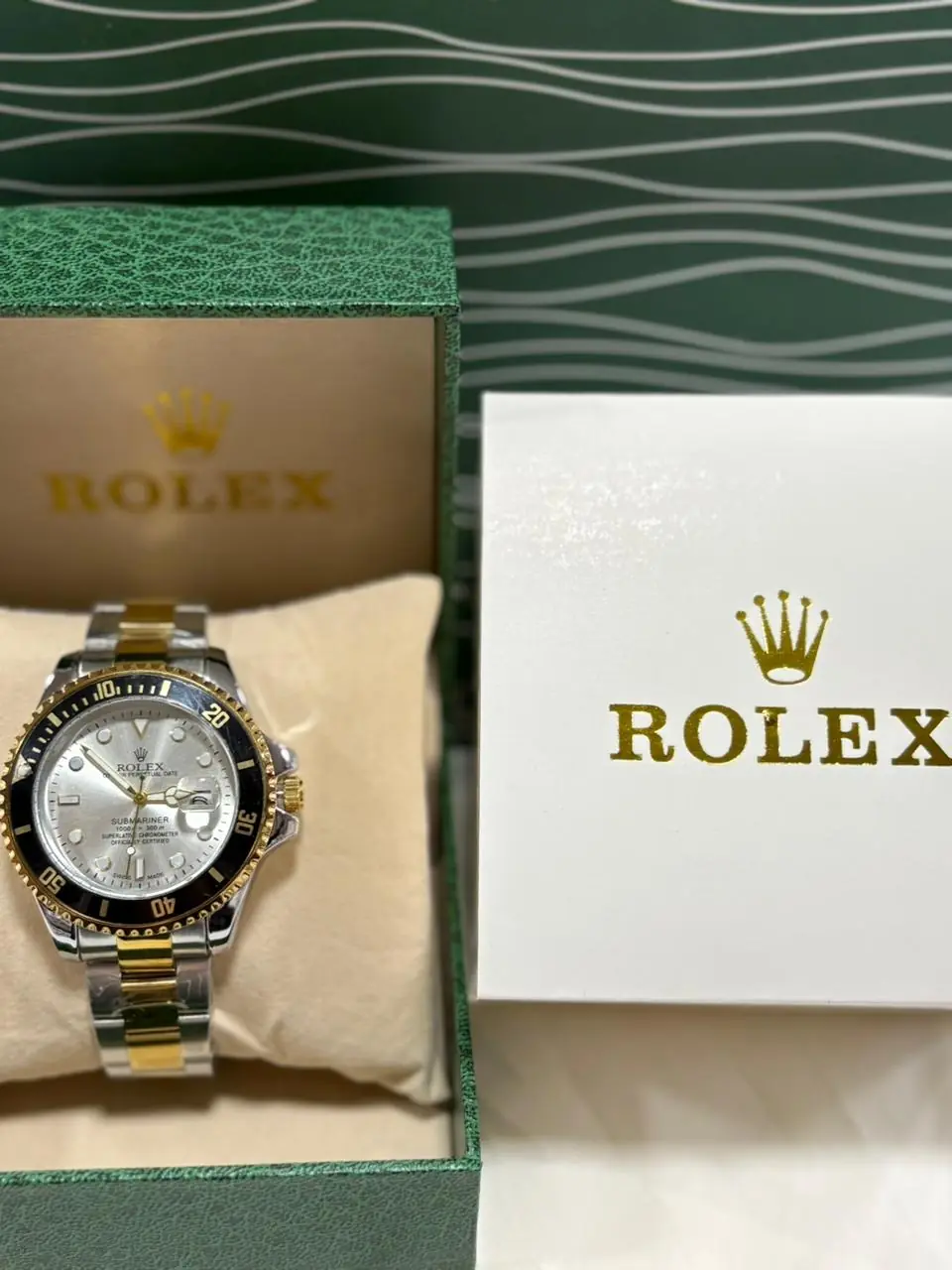 Rolex Submariner two-tone watch with a silver dial and black bezel.webp