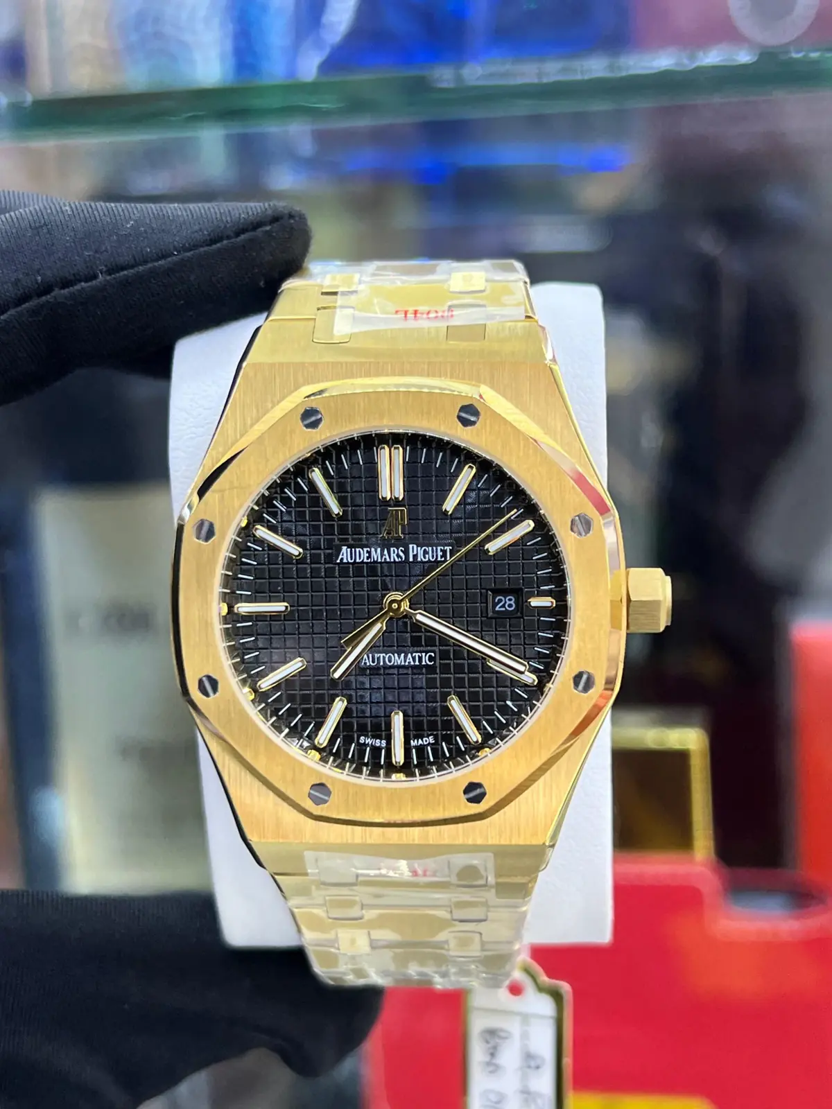 Audemars Piguet Royal Oak watch in a yellow gold-tone finish with a black Grande Tapisserie dial