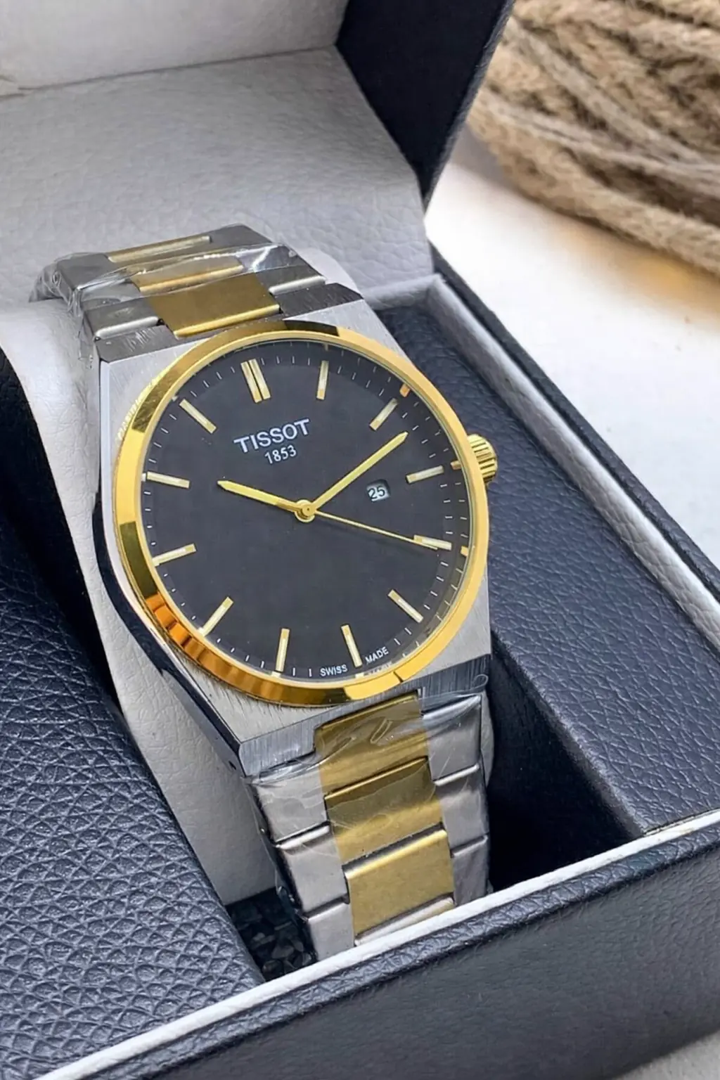 Tissot PRX watch with a black dial and a two-tone stainless steel bracelet