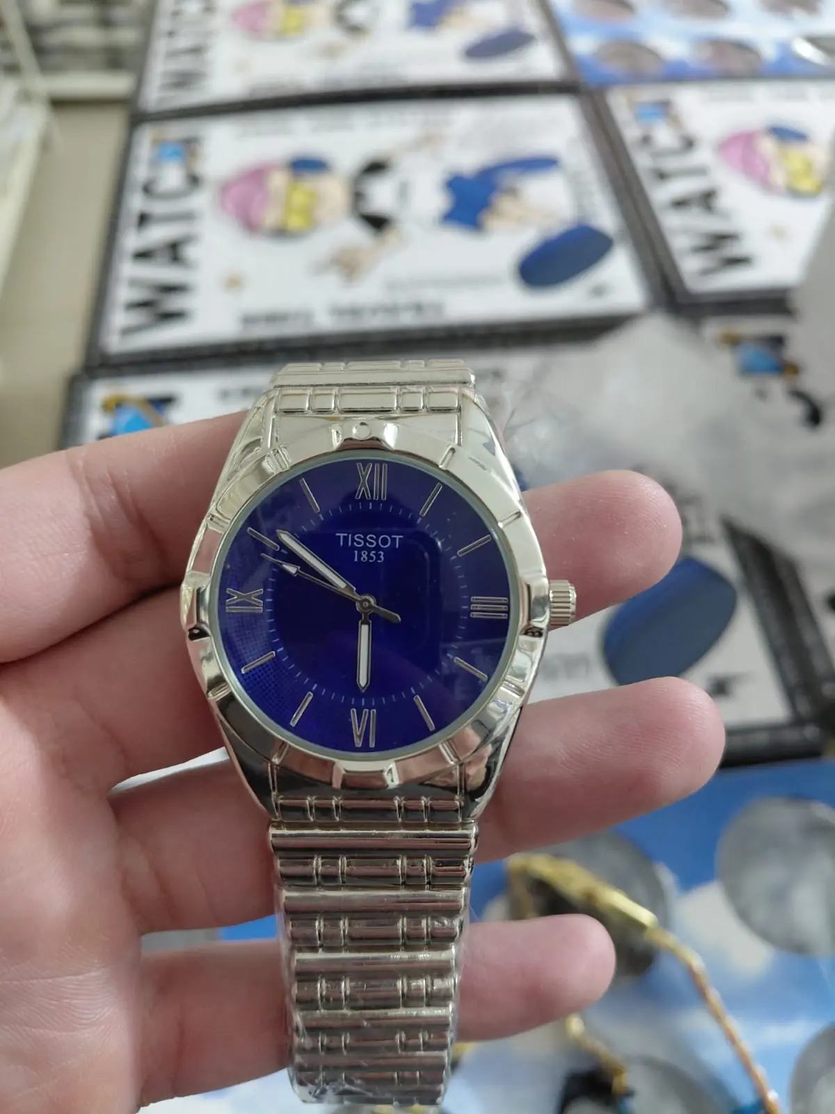 Tissot PR 100 watch with a blue dial and a stainless steel bracelet
